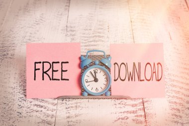 Ücretsiz İndirmeyi gösteren not yazılıyor. Dönüştürmedeki Görüntü Anahtarı Beleşçileri Başlat Kablosuz Görüntüler Mini mavi alarm saati iki kağıt teli arasında duruyor.