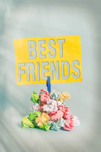 Handwriting text Best Friends. Concept meaning A an individual you value above other an individuals Forever buddies Reminder pile colored crumpled paper clothespin reminder blue background.