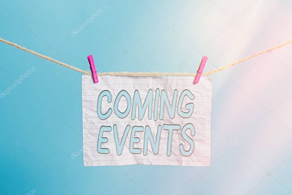 Handwriting text Coming Events. Concept meaning Happening soon Forthcoming Planned meet Upcoming In the Future Clothesline clothespin rectangle shaped paper reminder white wood desk.