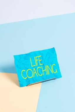 Conceptual hand writing showing Life Coaching. Business photo showcasing Improve Lives by Challenges Encourages us in our Careers Paper on buffer wire on soft pastel multi colours backdrop. clipart