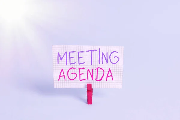 Konzeptionelle Handschrift, die die Meeting Agenda zeigt. Business photo showcasing Eine Agenda setzt klare Erwartungen für das, was zu einem Treffen benötigt Farbige Wäscheklammer rechteckförmigen Papier blauen Hintergrund. — Stockfoto