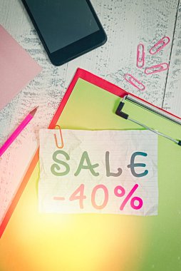 Satış tabelası% 40 'ı gösteriyor. Kavramsal fotoğraf% 40 indirimli bir ürünün reklam fiyatı Pano kağıdı akıllı telefon notu not defteri ahşap arkaplan kırpıyor.