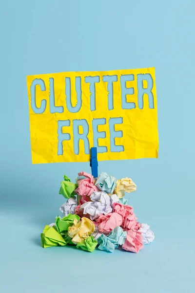 Handwriting text Clutter Free. Concept meaning Well organized and arranged Tidy All things in right places Reminder pile colored crumpled paper clothespin reminder blue background. — Stock Photo, Image