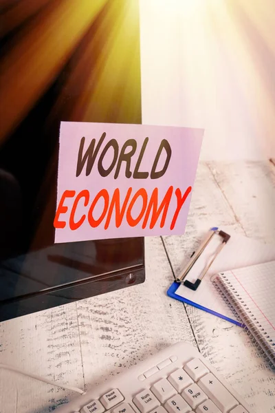 Word writing text World Economy. Business concept for Global Worldwide International markets trade money exchange Note paper taped to black computer screen near keyboard and stationary. — Stock Photo, Image