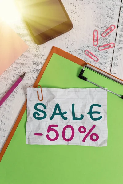 Text sign showing Sale 50 Percent. Conceptual photo A promo price of an item at 50 percent markdown Clipboard sheet pencil smartphone note clips notepad wooden background. — Stock Photo, Image