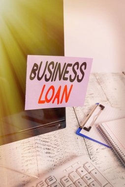 Kelime yazma İş Kredisi. Klavye ve durağan yakınındaki siyah bilgisayar ekranına bantlanmış Kredi İpotekli Finansal Yardım Notları Kağıdı konsepti.