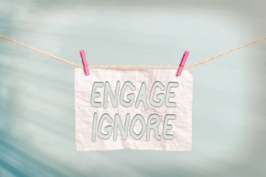 El yazısı metni Yoksay. Kavram, sessiz tedavi manipülatif cezalandırma somurtkan çamaşır ipinden sakınma çamaşır ipi dikdörtgen kağıt şekilli hatırlatıcı beyaz ahşap masa.