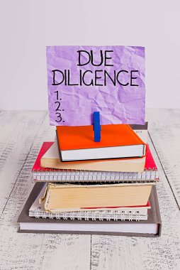 Handwriting text Due Diligence. Concept meaning Comprehensive Appraisal Voluntary Investigation Audit pile stacked books notebook pin clothespin colored reminder white wooden. clipart