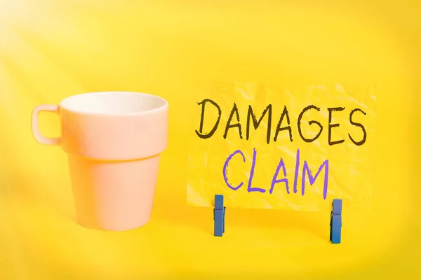 Conceptual hand writing showing Damages Claim. Business photo showcasing Demand Compensation Litigate Insurance File Suit Paper blue clothespin rectangle shape reminder yellow office. — Stock Photo, Image