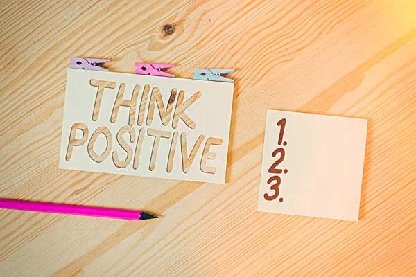 Conceptueel handschrift met Think Positive. Zakelijke fototekst De neiging om positief of optimistisch van houding te zijn Gekleurd verfrommeld papier houten vloer achtergrond wasknijper. — Stockfoto