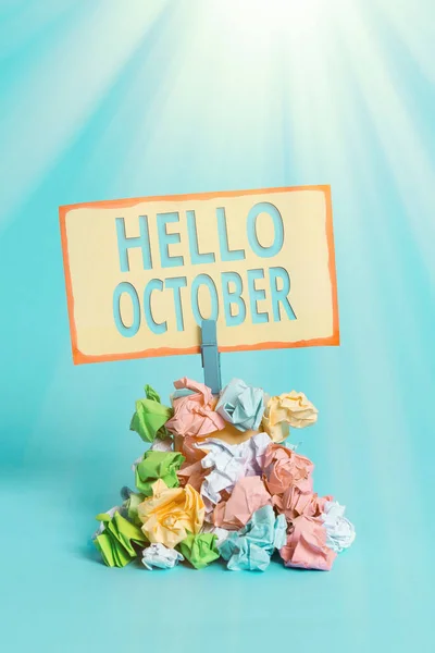 Text sign showing Hello October. Conceptual photo Last Quarter Tenth Month 30days Season Greeting Reminder pile colored crumpled paper clothespin reminder blue background. — Stock Photo, Image