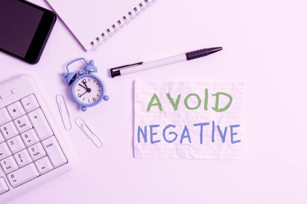 Handwriting text writing Avoid Negative. Concept meaning Staying away from pessimistic showing Suspicious Depression Flat lay above computer mobile phone clock pencil and copy space note paper.
