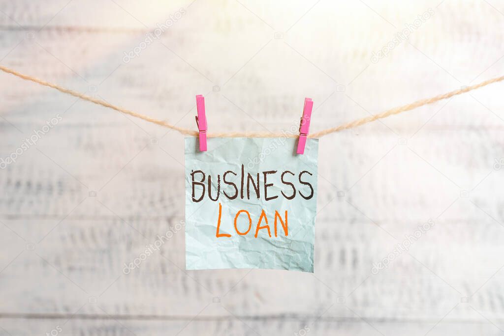 Writing note showing Business Loan. Business photo showcasing Credit Mortgage Financial Assistance Cash Advances Debt Clothesline clothespin rectangle shaped paper reminder white wood desk.