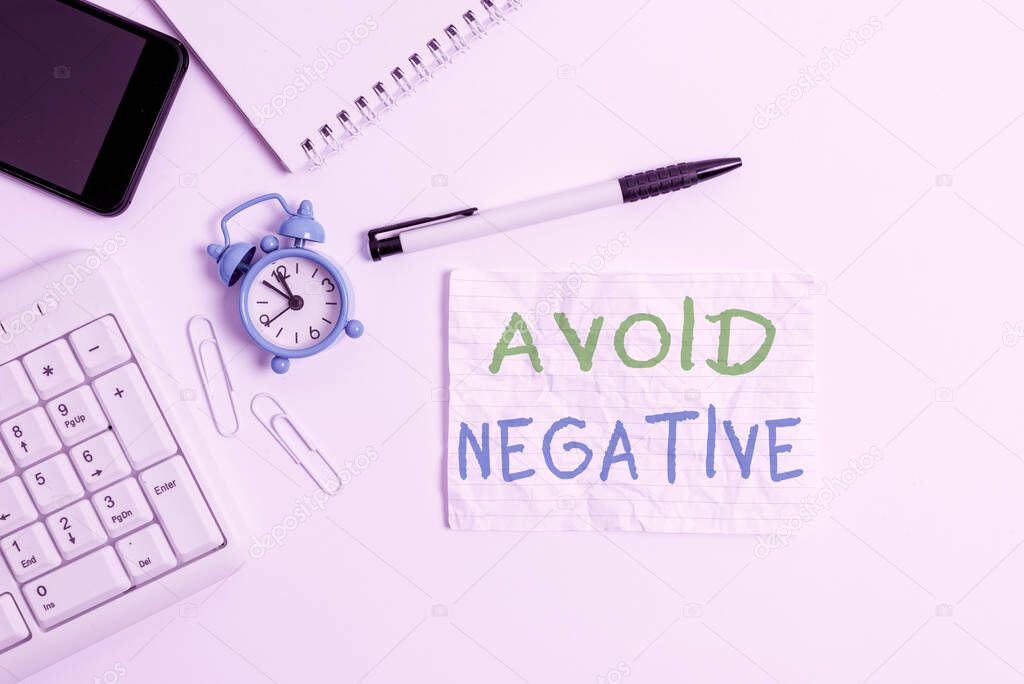 Handwriting text writing Avoid Negative. Concept meaning Staying away from pessimistic showing Suspicious Depression Flat lay above computer mobile phone clock pencil and copy space note paper.