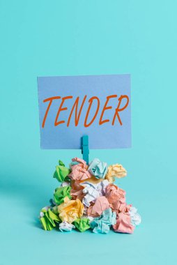 El yazısı Tender. Kavram, nezaket ve şefkat gösterme anlamına gelir. Acıya duyarlı. Renkli, buruşuk kağıt çamaşır tokası yığını..