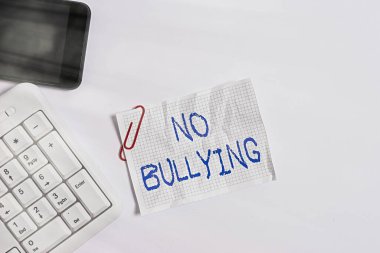 El yazısı metni. Zorbalık yok. Kavram, çocuklar arasındaki agresif davranışı durdurmak anlamına gelir güç dengesizliği beyaz arkaplan ve cep telefonu üzerinde boş not kağıdı ile beyaz pc klavye.