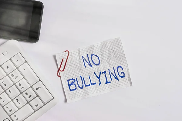 Handwriting text No Bullying. Concept meaning stop aggressive behavior among children power imbalance White pc keyboard with empty note paper above white background and mobile phone. — Stock Photo, Image