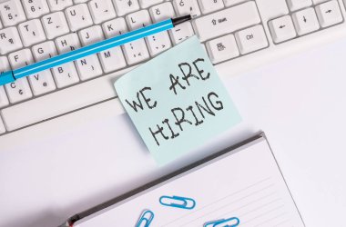 İşe aldığımızı gösteren bir not yazıyorum. İş fotoğrafçılığı son zamanlarda birini işe aldığınız ya da özel bir iş için para ödediğiniz boş fotokopi alanının üzerinde iş konsepti olan yapışkan notlar..