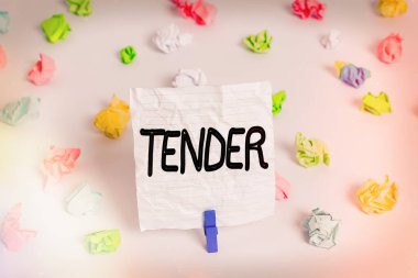Tender 'ı gösteren bir not yazıyorum. İş fotoğraflarında nezaket ve acıya karşı şefkat gösteriliyor. Renkli, buruşuk kağıt. Boş, hatırlatıcı, beyaz, çamaşır tokası..