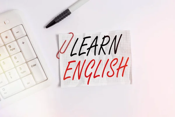 Texto de escritura de palabras Aprende inglés. Concepto de negocio para adquirir conocimientos en nuevo idioma por estudio Teclado blanco para PC con papel de nota vacío sobre fondo blanco . — Foto de Stock