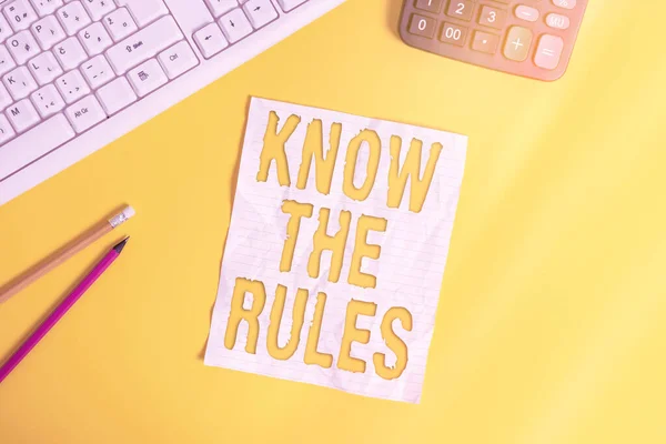 ルールを知ることを示すメモを書く。設定された明示的または規制の原則を紹介するビジネス写真行為を支配しますテーブル上のキーボードで黄色の背景の上にノートブック上のコピースペース. — ストック写真