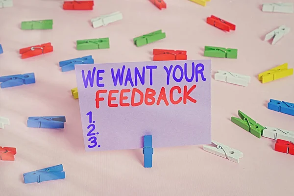 Handstilstextskrivning Vi vill ha din feedback. Begreppet mening kritik ges någon säga kan göras för förbättring Färgade klädnypor tom påminnelse rosa golv bakgrund kontor pin. — Stockfoto