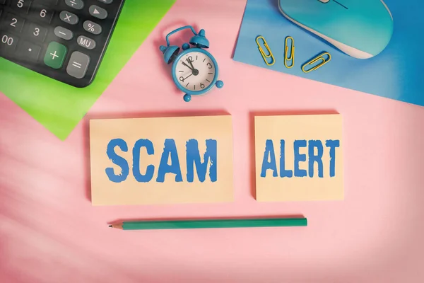 Scrivere testo Scam Alert. Concetto significato fraudolentemente ottenere soldi dalla vittima persuadendolo Filo calcolatore orologio del mouse blocchi note fogli marcatori clip colore sfondo . — Foto Stock