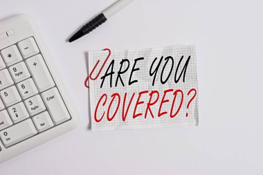 Kelime yazma metni Soruyu Kapsıyor musun? İş konsepti, iş yerinde mi yoksa hayatta mı sigortalı olduklarını sorar Beyaz PC klavyesinde beyaz arkaplanın üzerinde boş not kağıtları vardır.