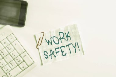El yazısı metin Çalışma Güvenliği. Beyaz arkaplan ve cep telefonu üzerinde boş not kağıdı ile beyaz pc klavye çalışanlarının sağlığını sağlamak için uygulanan politikalar ve prosedürler.