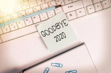 Elveda 2020 'yi gösteren bir not yazılıyor. İş fotoğrafı gösterimi ayrılırken veya geçen yılın sonunda iyi dileklerinizi iletirken boş fotokopi alanının üzerinde iş konseptiyle birlikte yatıyordunuz..