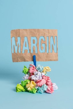 Margin 'i gösteren bir not yazıyorum. İş fotoğraflarında satışlardan elde edilen gelirin, bir iş hatırlatma yığınındaki maliyetleri aştığı, buruşmuş kağıt çamaşır mandalı, ahşap..