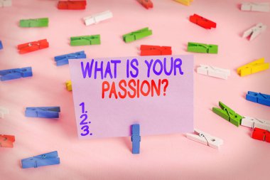 Tutkunuz Sorusu 'nu yazan el yazısı metni. Kavram, onun güçlü ve zar zor kontrol edilebilir duygularını sormaktır. Renkli çamaşır mandalı kağıtları boş hatırlatıcı, pembe zemin arka plan ofisi.