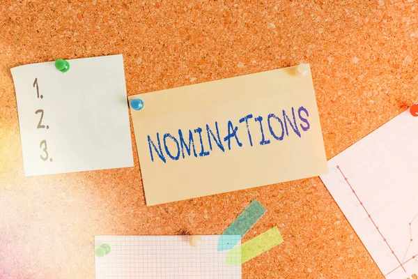 Woord schrijven tekst Nominaties. Zakelijk concept voor actie van nomineren of staat wordt genomineerd voor prijs Corkboard kleur grootte papier pin thumbtack tack blad billboard mededelingenbord. — Stockfoto