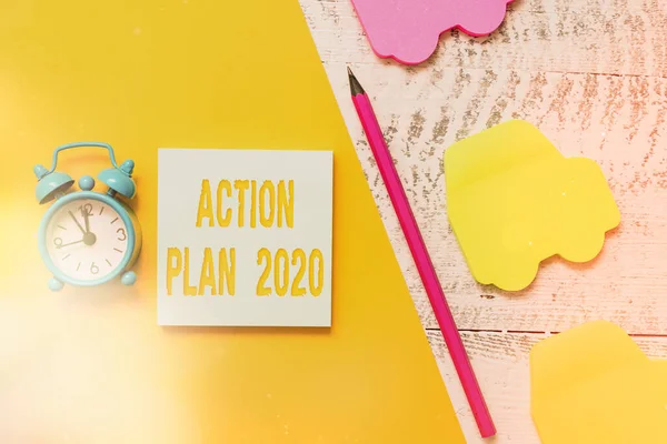Text sign showing Action Plan 2020. Conceptual photo proposed strategy or course of actions for current year Notepad car sticky notes pen paper sheet alarm clock wooden background.