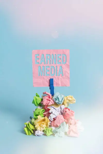 Conceptual hand writing showing Earned Media. Business photo showcasing Publicity gained through promotional efforts by multimedia Reminder pile colored crumpled paper clothespin wooden space. — Stock Photo, Image