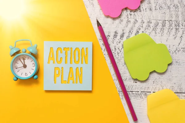 Text sign showing Action Plan. Conceptual photo proposed strategy or course of actions for certain time Notepad car sticky notes pen paper sheet alarm clock wooden background.