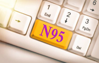 N95 'i gösteren bir not yazıyorum. Giyen kişiyi korumak için kullanılan bireysel koruma ekipmanlarını gösteren iş fotoğrafı..