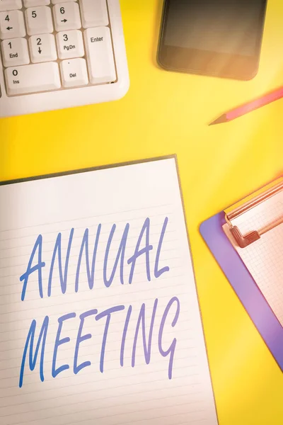 年度会议的概念手写体。在工作台时钟移动键盘和pc键盘上显示一个组织的普通会员年会的商业照片. — 图库照片