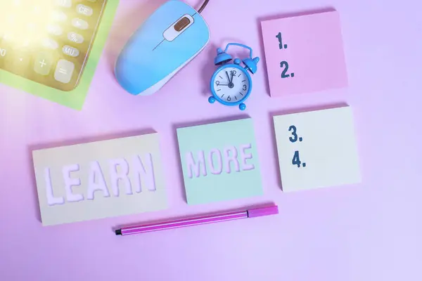 글을 쓰는 법을 더 배우 십시오. 개념은 지식이나 기술을 습득하는 과정에서 얻게 되는 사려깊은 학습 노트 패드 마우스 알람 시계 표지 배경에 색을 입힌 마커. — 스톡 사진