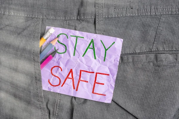 Conceptual hand writing showing Stay Safe. Business photo text secure from threat of danger, harm or place to keep articles Writing equipment and purple note paper inside pocket of trousers.