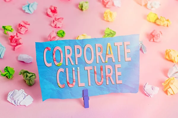 Word writing text Corporate Culture. Business concept for pervasive values and attitudes that characterize a company Colored crumpled papers empty reminder pink floor background clothespin.