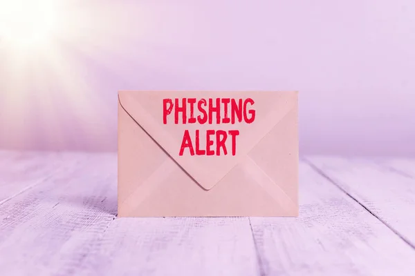 Handwriting text writing Phishing Alert. Concept meaning aware to fraudulent attempt to obtain sensitive information Closed standing rectangular colored envelope old wooden vintage background.