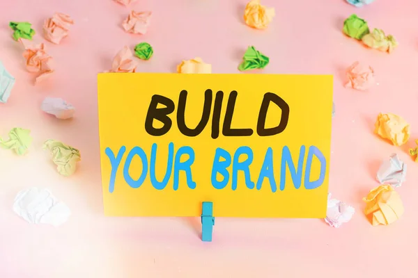 브랜드 구축을 보여 주는 문자 표지판. 광고 캠페인을 사용하여 브랜드의 공정성을 강화하는 컨셉 사진 컬러 매핑빈 종이 핑크 플로팅을 떠올리게 한다.. — 스톡 사진