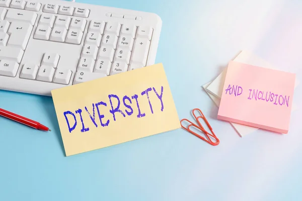 Writing note showing Diversity And Inclusion. Business photo showcasing range difference includes race ethnicity gender Paper blue keyboard office study notebook chart numbers memo.