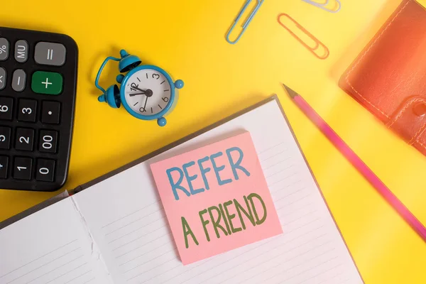Text sign showing Refer A Friend. Conceptual photo direct someone to another or send him something like gift Notebook wallet calculator clips pencil note alarm clock color background. — Stock Photo, Image