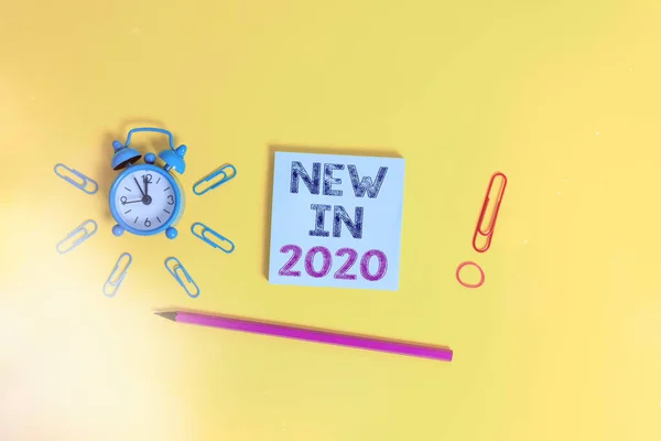 Foto de negócios mostrando o que estará esperando ou nova criação para o ano 2020 Clipes de despertador de despertador elástico lápis notepad fundo colorido . — Fotografia de Stock