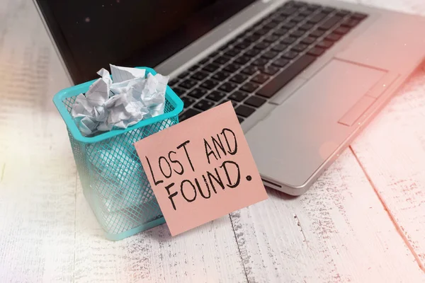 Text sign showing Lost And Found. Conceptual photo a place where lost items are stored until they reclaimed Metallic laptop sticky note pad waste basket crushed paper vintage table. — Stock Photo, Image