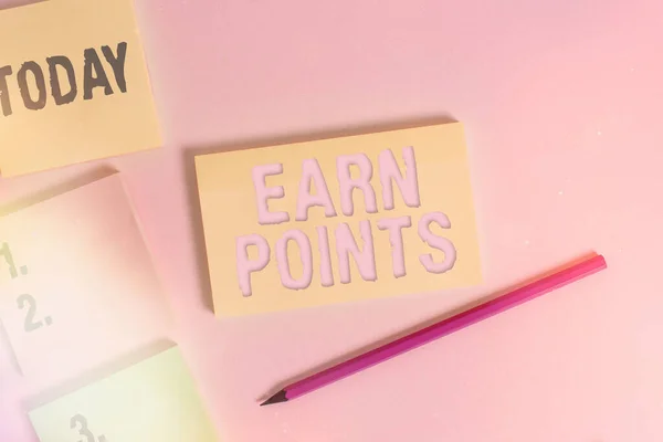Text sign showing Earn Points. Conceptual photo getting praise or approval for something you have done Close up view four multicolor blank notepads marker colored background.