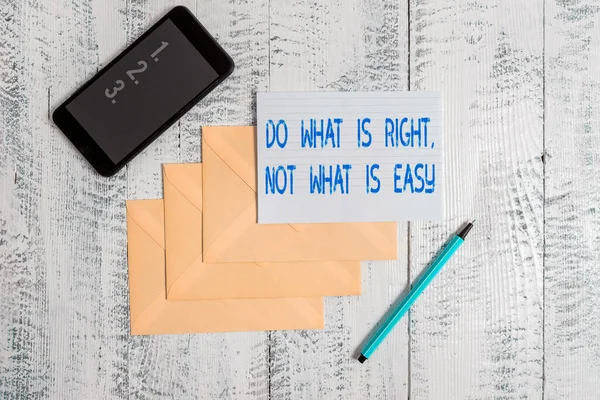 Conceptual hand writing showing Do What Is Right Not What Is Easy. Business photo showcasing willing to stand up for what is right Envelopes marker ruled paper smartphone wooden background.