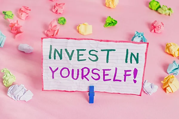 Text sign showing Invest In Yourself. Conceptual photo learn new things or materials thus making your lot better Colored crumpled papers empty reminder pink floor background clothespin.